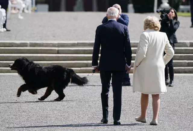 US President Joe Biden with Irish President Michael D Higgins’ wife Sabina as the Irish president’s dog Misneach runs past at Aras an Uachtarain in Phoenix Park, Dublin