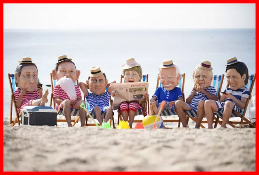 Oxfam campaigners pose as G7 leaders on Swanpool Beach near Falmouth, Cornwall