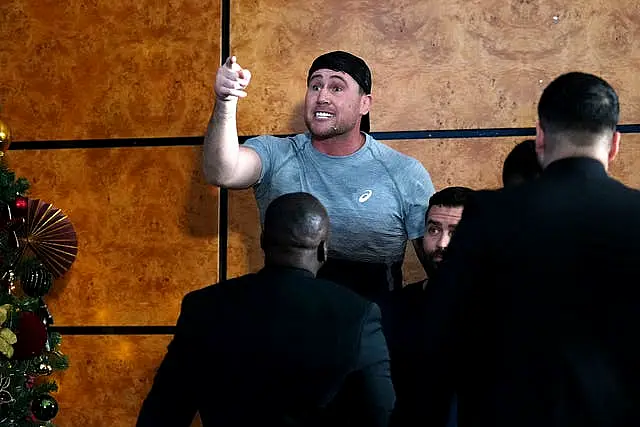 Darren Till reacts with finger raised and surrounded by security after John Fury (not pictured) appears to throw a bottle of water towards him during a press conference