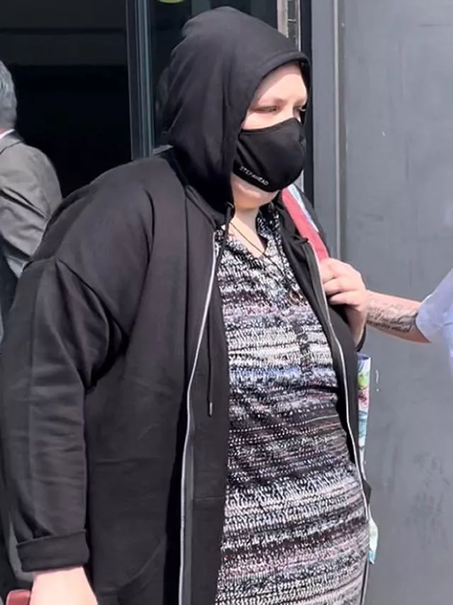 A woman with a face mask and a hooded jacket