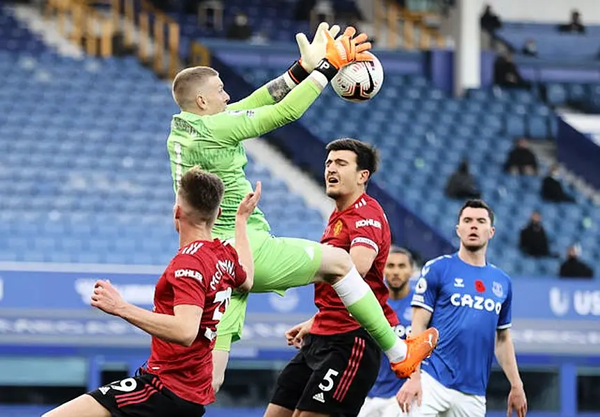 Everton goalkeeper Jordan Pickford gathers the ball while under pressure