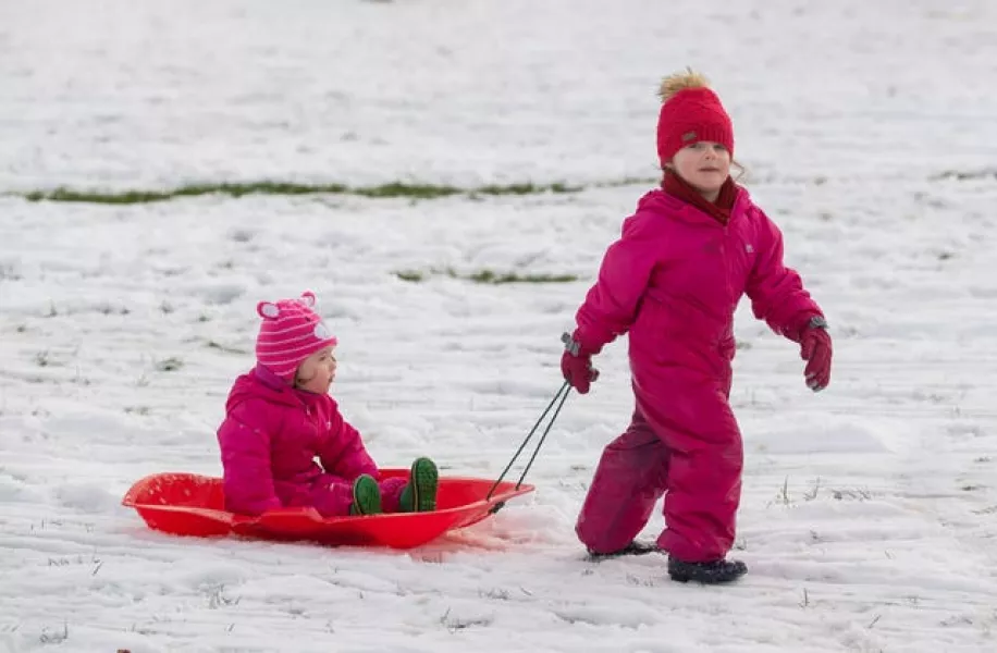 Children sledge down hill