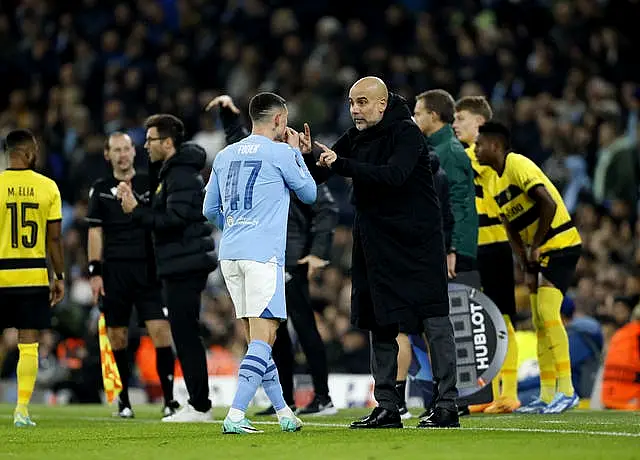 Pep Guardiola, right, speaks to Phil Foden on the pitch at full-time