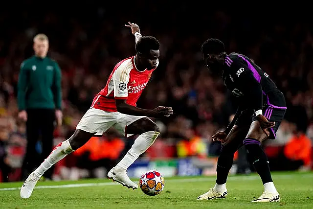 Arsenal’s Bukayo Saka, left, runs at Bayern Munich's Alphonso Davies