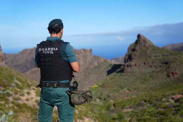 A Spanish police officer looking over a valley in Tenerife with the sea in the distance