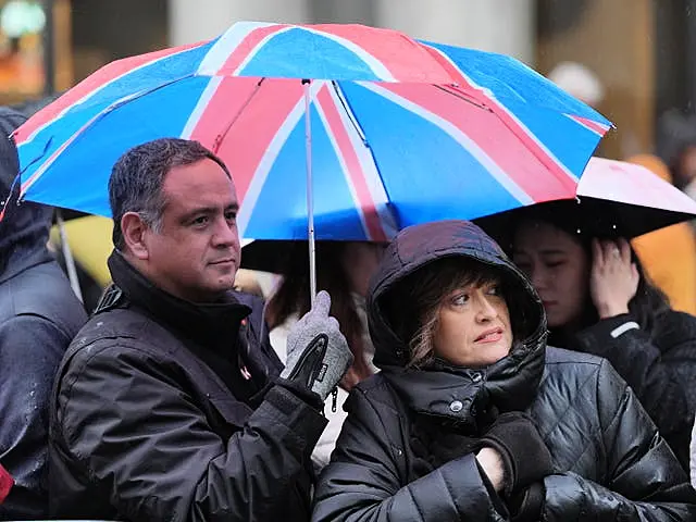 Rain falls as people gather to watch the New Year’s Day Parade in central London. 