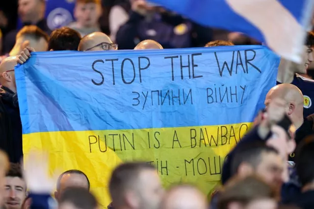 Scotland fans hold up a Ukraine flag reading “Stop the War”