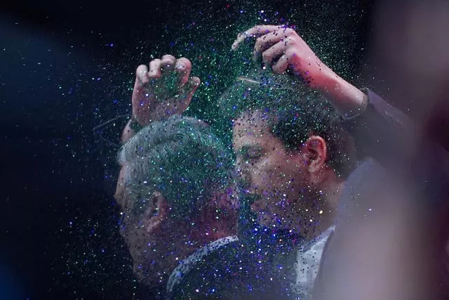 A protester throws glitter over Sir Keir Starmer