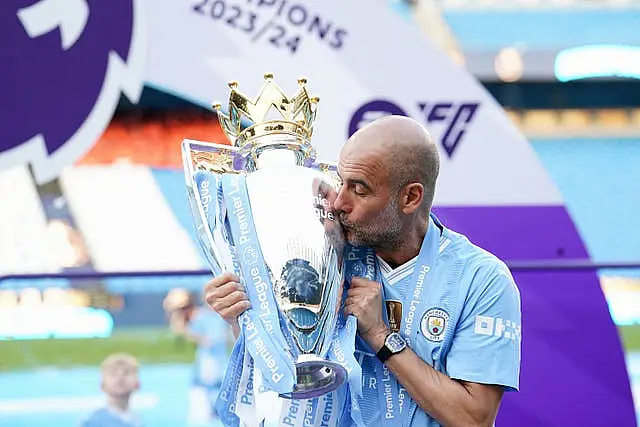 Manchester City manager Pep Guardiola kisses the Premier League trophy