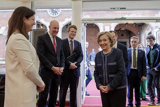 Hillary Clinton smiles as she is greeted at an event at Queen's University