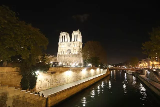 A night-time view of the River Seine as it flows past Notre-Dame cathedral