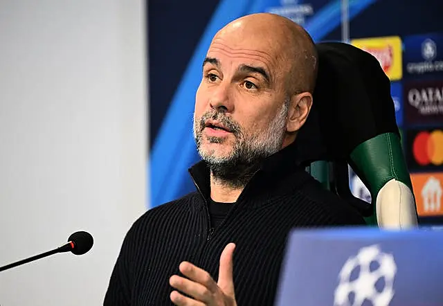 Pep Guardiola speaks into a microphone during a press conference