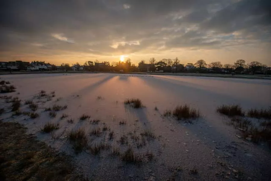 Rushmere Pond as the sun rises over Wimbledon Common, south London, during the cold snap 