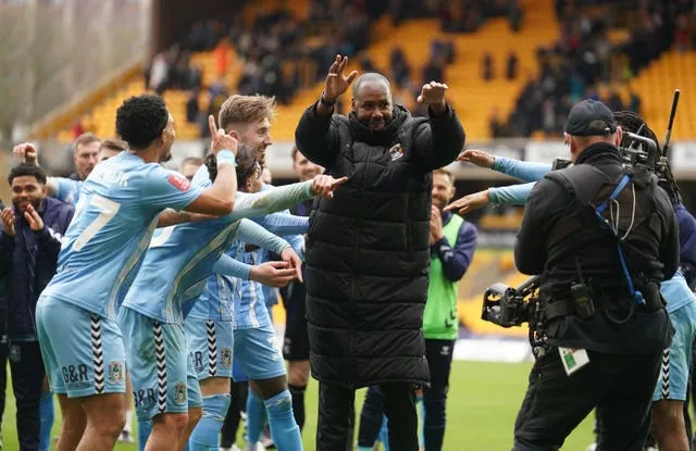 Coventry first-team coach Dennis Lawrence celebrates victory with the players