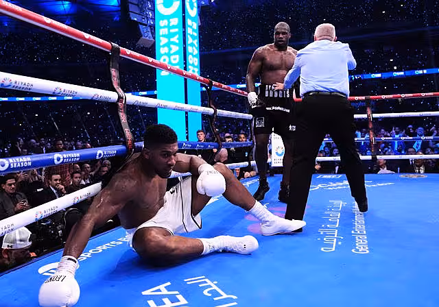 Anthony Joshua sits on the canvas after Daniel Dubois knocked him down at Wembley
