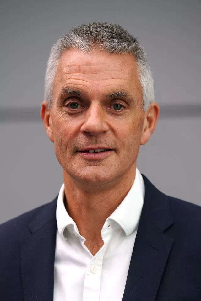 Head and shoulders shot of a man in open-neck white shirt