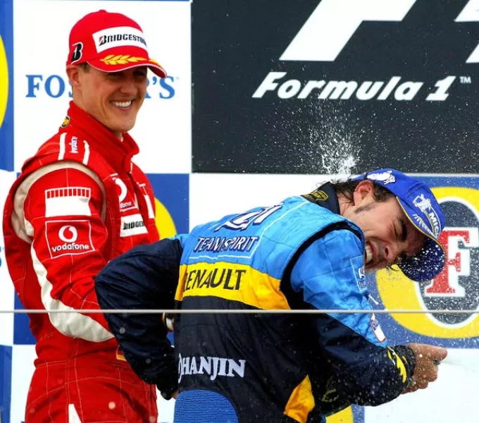 Michael Schumacher (left) sprays champagne on Fernando Alonso