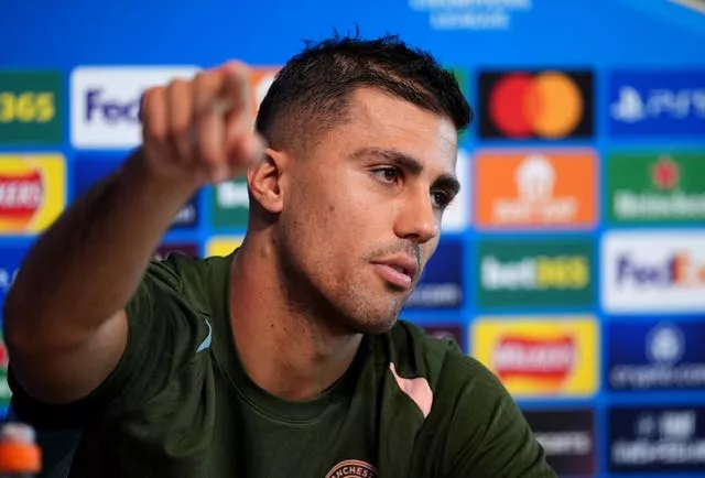 Rodri points during a press conference