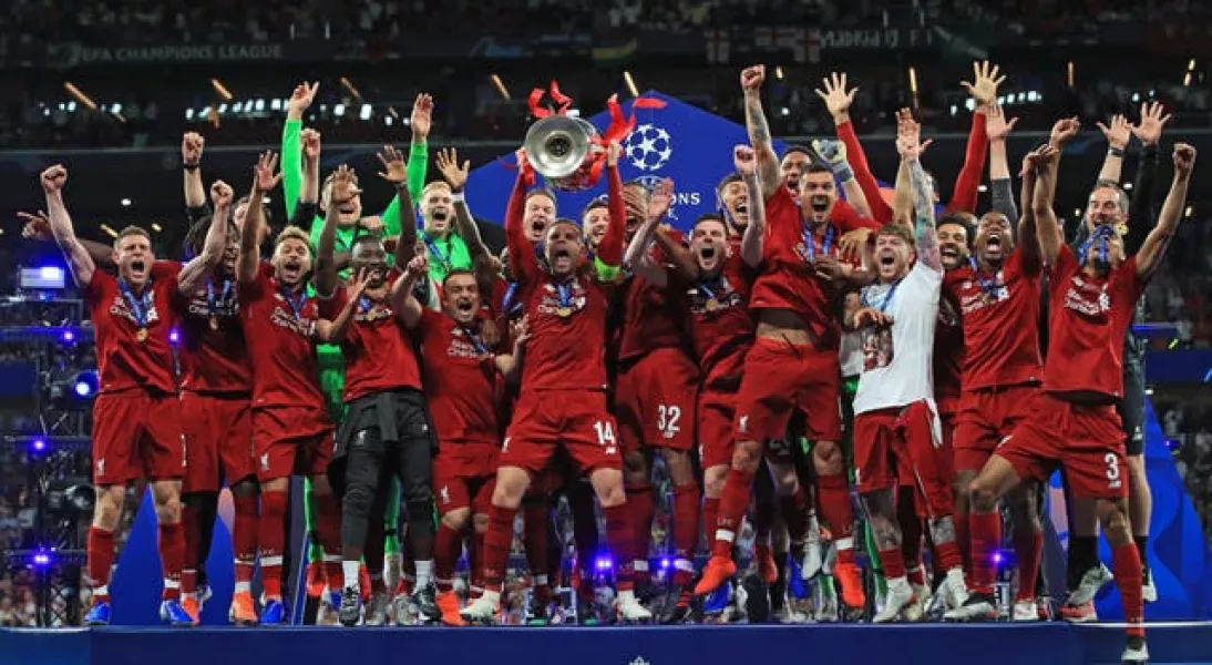 Liverpool’s Jordan Henderson lifts the trophy with his team-mates after winning the Champions League in 2019