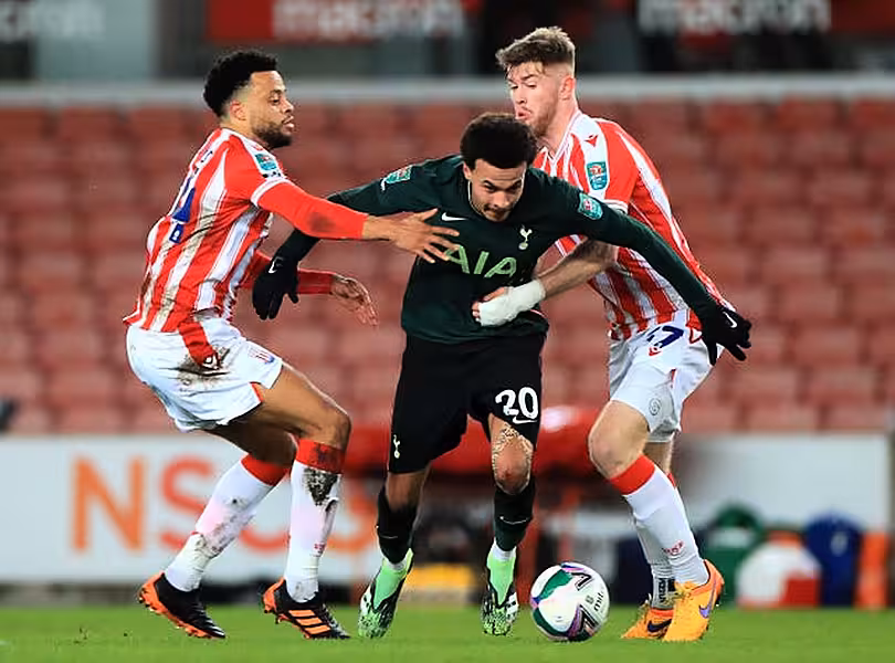 Dele Alli, centre, takes on Jordan Cousins, left, and Nathan Collins