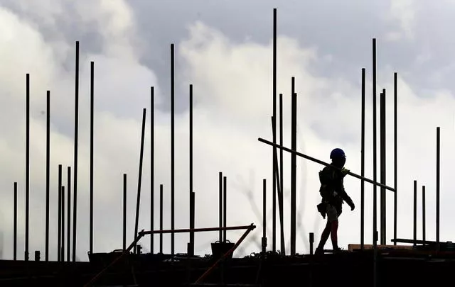 Silhouette of builder on roof of house