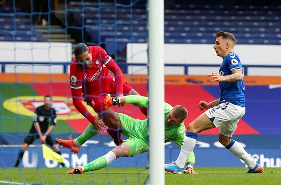 Everton goalkeeper Jordan Pickford tackles Liverpool defender Virgil Van Dijk