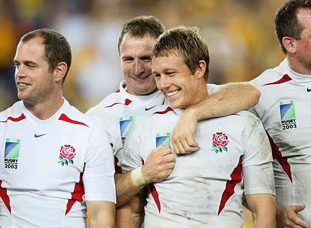 Jonny Wilkinson (centre right) is congratulated by team-mate Mike Catt after his drop goal clinched the 2003 Rugby World Cup