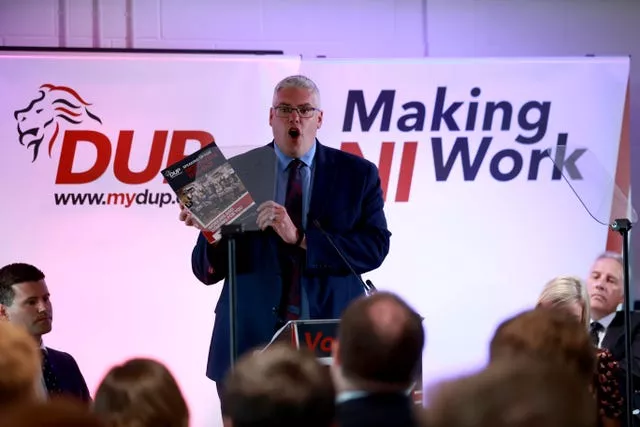 DUP leader Gavin Robinson holding a copy of the party’s manifesto