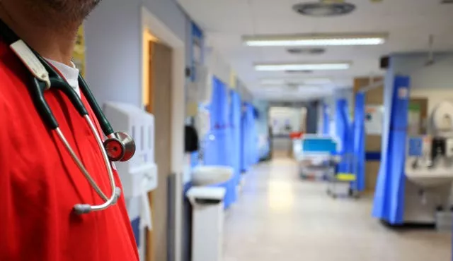 A medic in red scrubs on a hospital ward