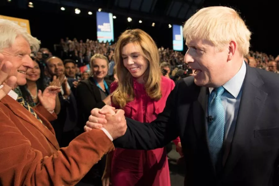 Prime Minister Boris Johnson leaves the stage with his partner Carrie Symonds as he is congratulated by his father Stanley Johnson after delivering his speech during the Conservative Party Conference at the Manchester Convention Centre 