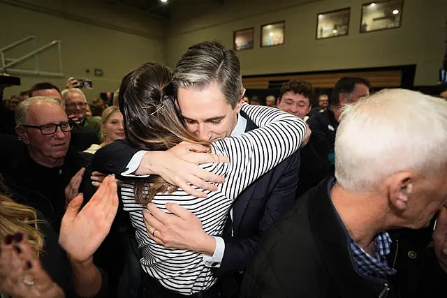 Simon Harris is hugged by his wife