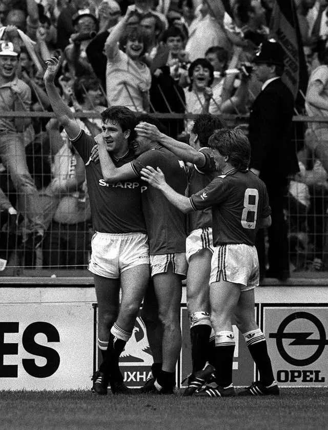 Manchester United match-winner Norman Whiteside (left) is mobbed by his team-mates after scoring against Everton at Wembley