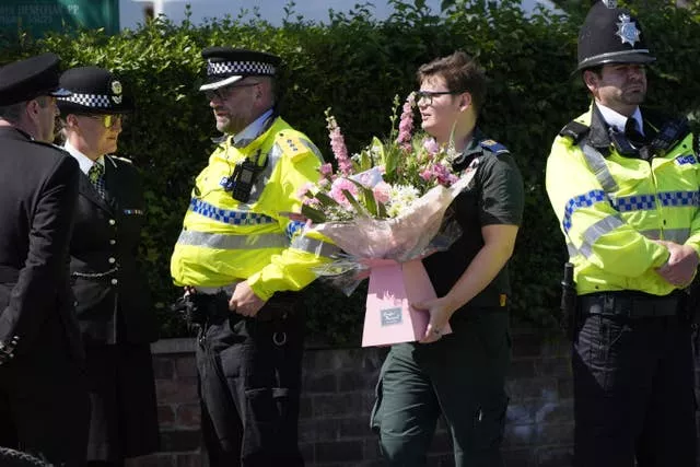 A paramedic carries flowers ahead of the funeral of Southport stabbing victim Alice da Silva Aguiar