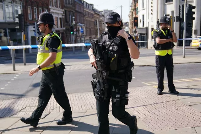 An armed police officer with two unarmed colleagues.