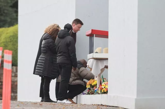 People lay wreaths at a commemoration and remembrance service in Creeslough on the first anniversary of the explosion