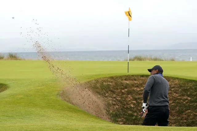 Tiger Woods chips out of a bunker during the first round of the Open at Royal Troon