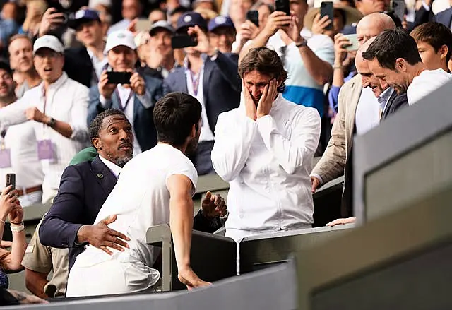 Carlos Alcaraz climbs up to celebrate with coach Juan Carlos Ferrero 