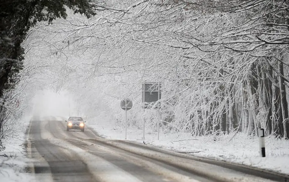 A car makes its way along a snow-covered road in Kent