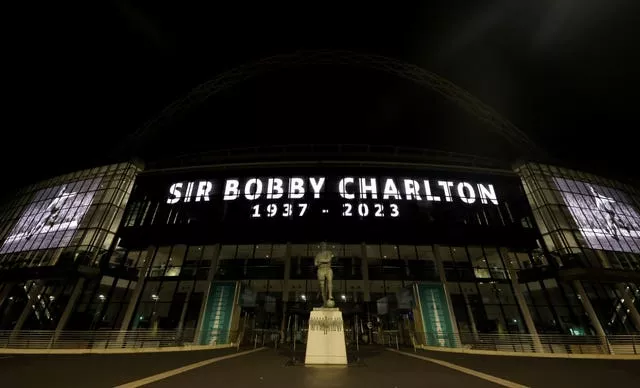A tribute to Sir Bobby Charlton is displayed on giant screens outside Wembley Stadium 