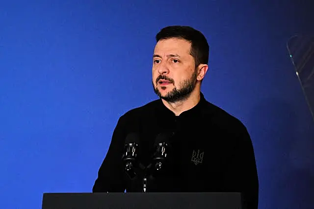 Volodymyr Zelensky speaking at a lectern