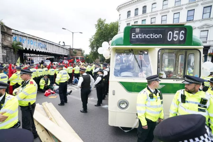 Police and demonstrators with a bus parked on London Bridge (Ian West/PA)
