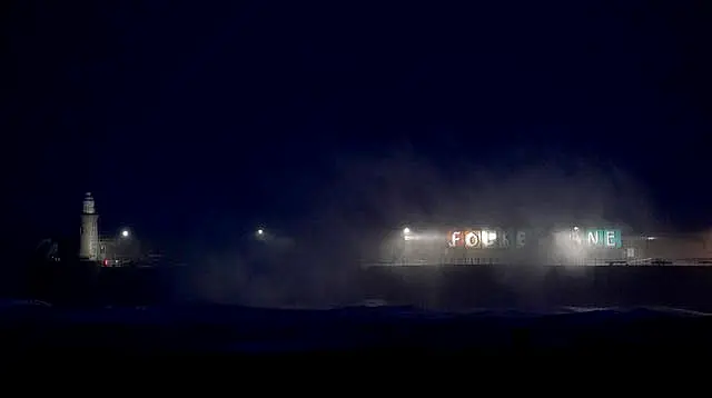 Waves crash over the harbour arm in Folkestone, Kent