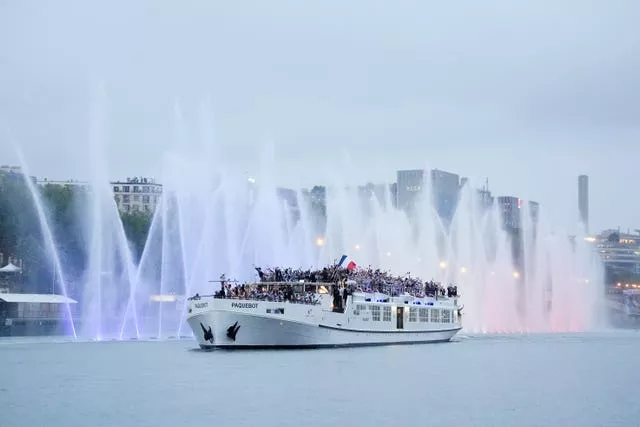 A boat carrying the French team travels down the Seine