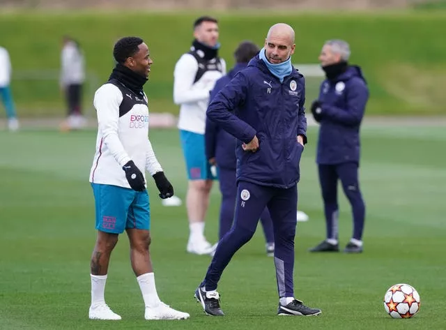 Pep Guardiola talks to Raheem Sterling in training at City