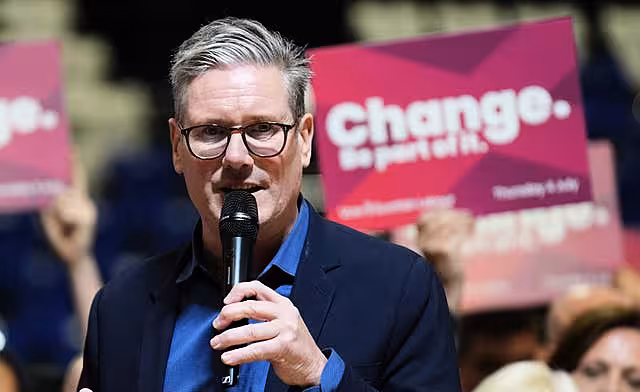 Sir Keir Starmer speaks into a microphone in front of a crowd