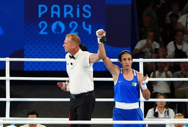 Imane Khelif has her hand raised after her women's middleweight semi-final