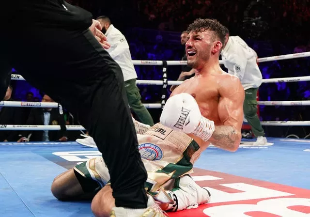 Leigh Wood, on his knees, celebrates victory over Michael Conlan after their WBA Featherweight World Title contest