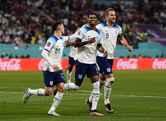 Marcus Rashford, centre, celebrates a World Cup goal with Harry Kane, right, and Phil Foden