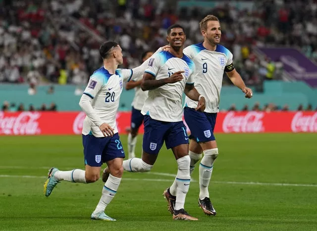 Marcus Rashford, centre, celebrates a World Cup goal with Harry Kane, right, and Phil Foden