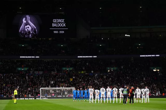 Players from both teams and fans stand in memory of George Baldock ahead of the Nations League match between England and Greece at Wembley